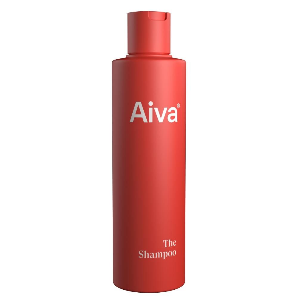AIVA The Shampoo comes in a red plastic bottle with a flip-top cap. The bottle is cylindrical and smooth, displaying the brand name “AIVA” in large white letters near the top and “The Shampoo” at the bottom. The packaging has minimal graphics or text aside from these labels. The image shows only the product against a plain background.