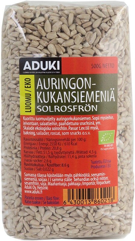 Aduki Luomu Auringonkukansiemen: 500 g:n Aduki-luomu auringonkukansiemenpakkaus suomen- ja ruotsinkielisellä tekstillä, ainesosat, ravintotiedot ja viivakoodi etuosassa; suorakulmainen pakkaus on pääosin mattavalkoinen läpinäkyvällä ikkunalla, jonka läpi näkyy auringonkukansiemeniä; tumma lihavoitu kirjasin bränditekstille; ei ihmisiä tai käsiä näkyvissä, tausta on vaalea ja yksinkertainen.