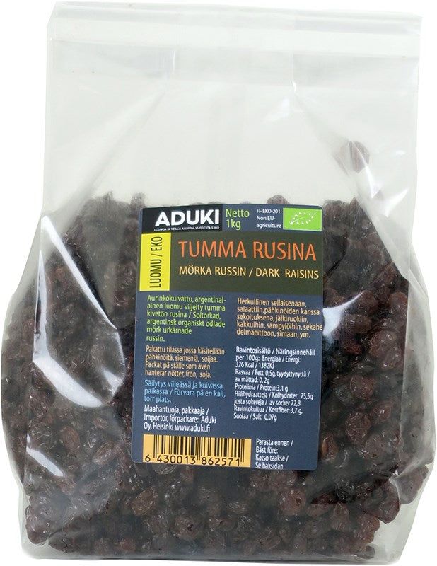 Aduki Luomu Tumma Rusina; kirkas, kiiltäväpintainen muovipussi tekstillä Aduki Tumma Rusina sisältää 1 kg luomurusinoita; pakkaus suorakaiteen muotoinen, suljettu ylä- ja alaosasta, tuotetieto useilla kielillä yksinkertaisin groteskifontein, vihreä luomusertifiointimerkki; tausta valkoinen, kuva suoraan edestä, ei ihmisiä tai käsiä.