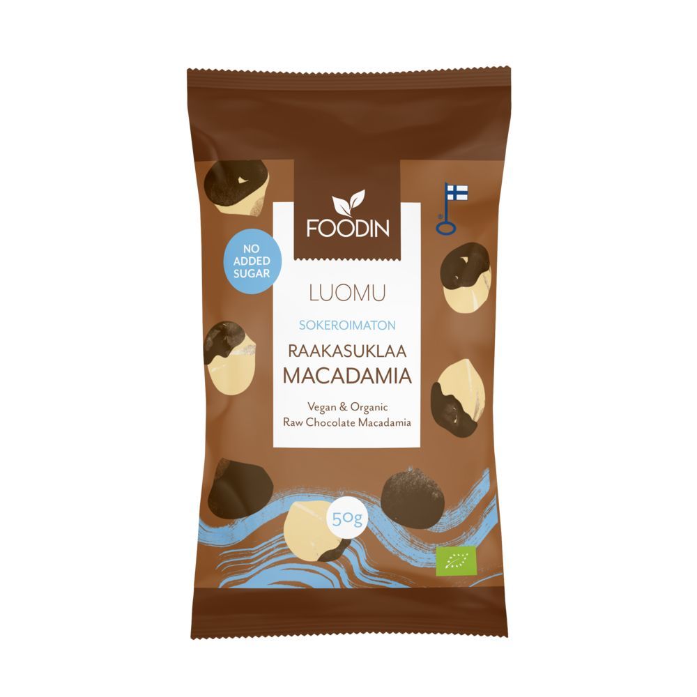 Foodin Luomu Sokeroimaton Raakasuklaamacadamia; ruskea, mattapintainen 50 g:n pussi suorakulmaisena pystyssä; teksti "Raw Chocolate Macadamia" lihavoidulla valkoisella groteskifontilla; alla kuva suklaakuorrutetuista macadamiapähkinöistä; selkeät kuvakkeet "No Added Sugar", "Vegan" ja "Organic"; suomalaiset ja EU:n luomusertifiointilogot näkyvissä; neutraali tausta, ei ihmisiä tai tarvikkeita.