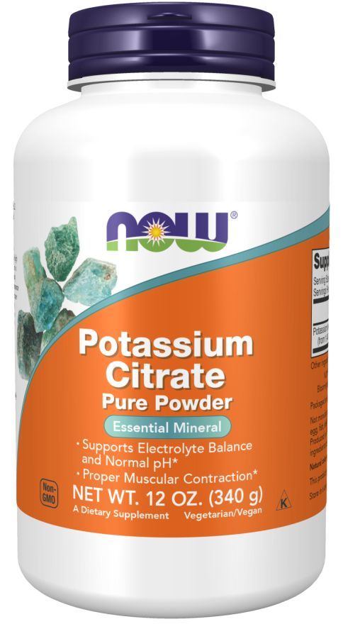 Now Foods Potassium Citrate Powder, valkoinen muovipullo mattapinnalla ja oranssilla etiketillä; pullo sylinterimäinen kierrekorkillinen; etiketissä sinivihreitä kristallikuvia, lihavoitua groteskitypografiaa sekä tekstiä kuten "essential mineral", "electrolyte balance" ja "muscle contraction"; tausta neutraali studiokuva, ei ihmisiä näkyvissä.
