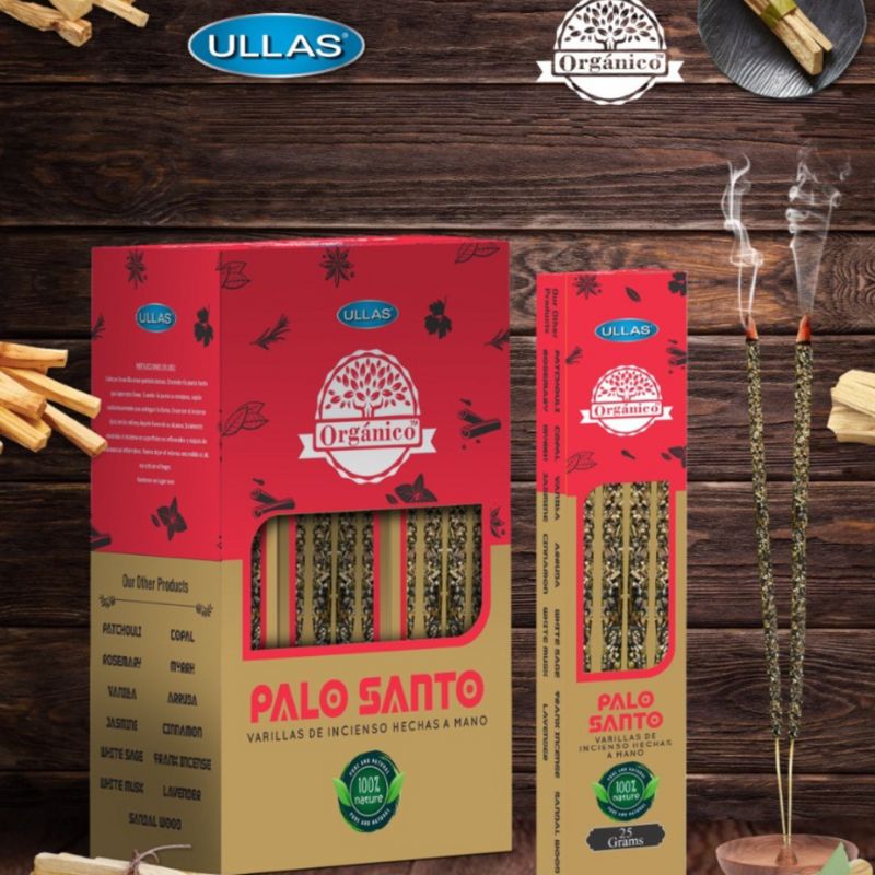 Two boxes of Ullas Orgánico Palo Santo incense sticks, one large and one small, are displayed with incense sticks burning and emitting smoke. Boxes have matte red and beige surfaces with floral graphics. Both boxes are rectangular; the visible label text includes product name and organic information in bold sans-serif font. The background is plain with no people or hands visible. This is a straightforward product shot.