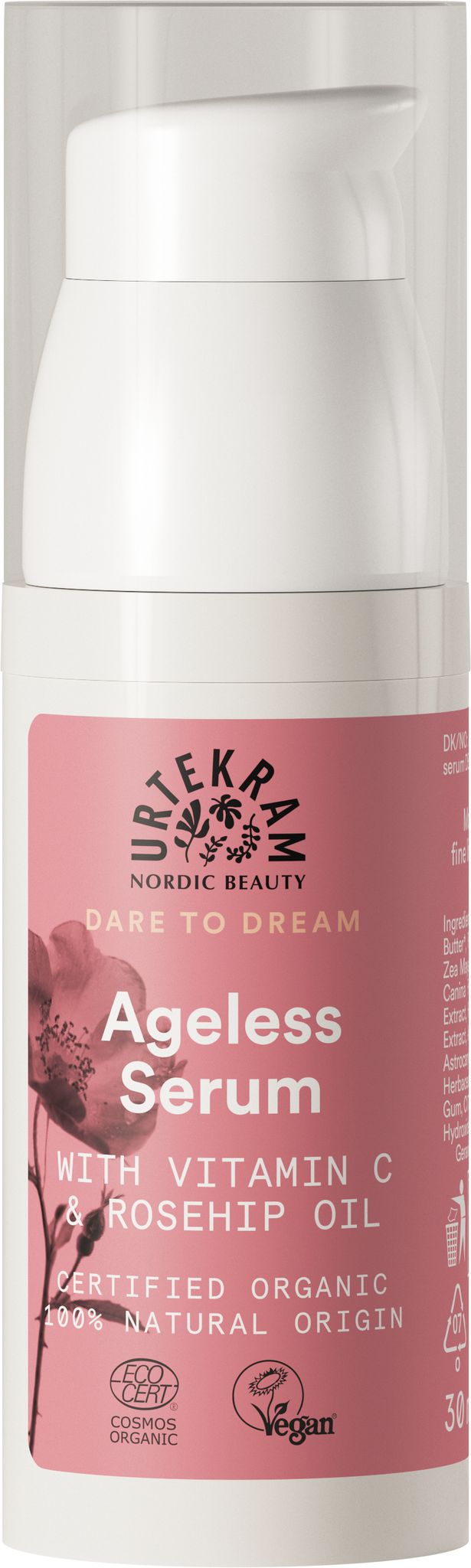 A bottle of Urtekram Ageless Serum with Vitamin C, Rosehip Oil, and vegan ingredients. The label highlights that it is certified organic and made from 100% natural origin. The packaging features a pink floral design. The bottle is cylindrical with a matte finish and pump dispenser. Label text uses clear sans-serif font in white and silver on a pink background. No people or hands are visible, plain backdrop, centered product shot.