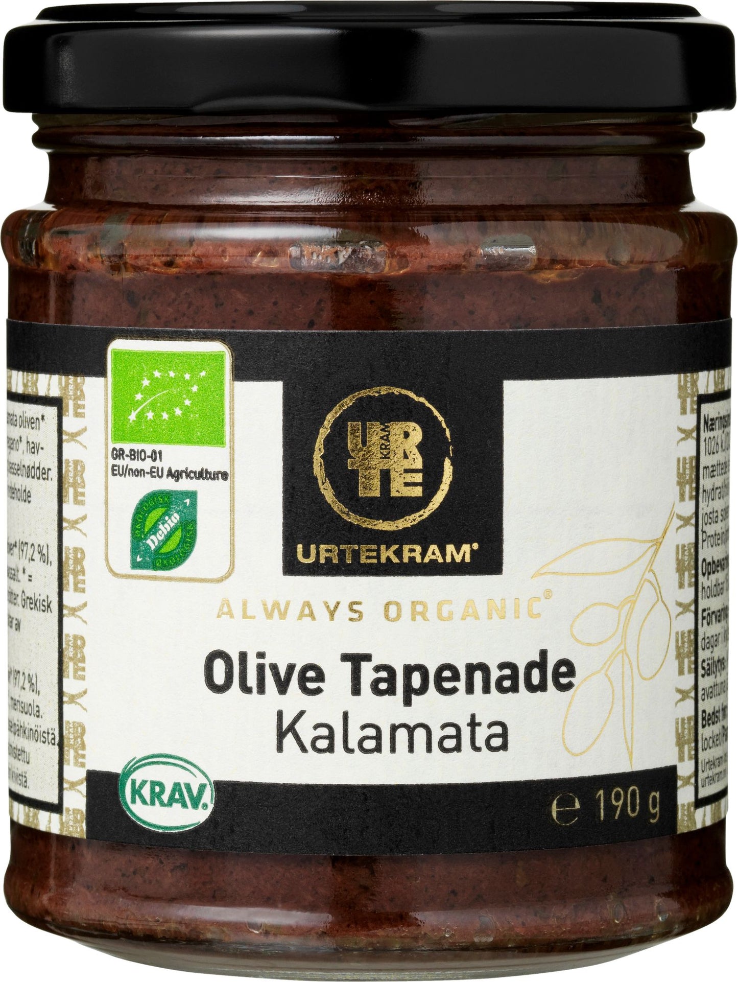 A glass jar of Urtekram Organic Olive Tapenade Kalamata, 190g, with a black metal lid and a matte-finish label. The label is predominantly white and green, featuring legible text including the product name, organic and KRAV certification logos, and an illustrated olive branch. Sans-serif typography is used. The background is plain white with no people or hands visible in the shot.