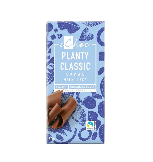 A blue and white patterned iChoc Planty Classic vegan milk-like chocolate bar, featuring fair trade, organic, and no plastic labels, with chocolate curls and an 80g weight shown on the packaging. Rectangular cardboard wrapper with a matte surface. Sans-serif font for main text; all product claims in small icons near bottom corner. Flat lay shot against a plain neutral background. No people or hands visible.