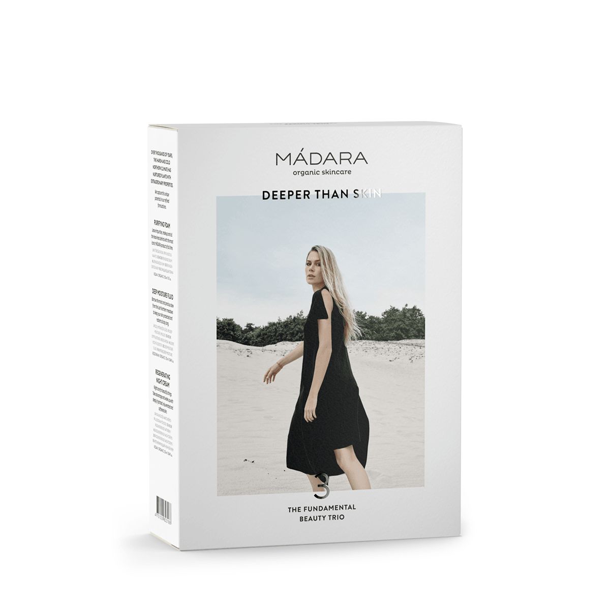 MÁDARA Become Organic -pakkaus, kuvassa nainen mustassa mekossa kävelemässä hiekalla, tekstissä "DEEPER THAN SKIN" ja "THE FUNDAMENTAL BEAUTY TRIO", korostaen luonnollisia raaka-aineita; suorakulmainen pakkaus mattapinnalla, valokuvaa ja tekstausvapaata typografiaa; vain osa tuotesarjasta näkyvissä; kuvan tausta valkoinen, studiokuva.