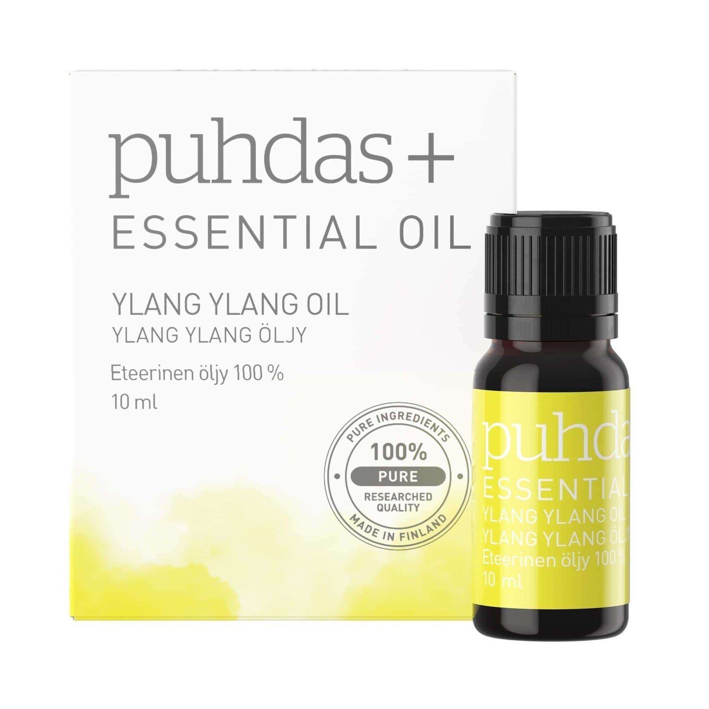 Puhdas+ Eteerinen Ylang Ylang öljy; rasia ja pieni pullo Puhdas+ eteeristä öljyä, merkitty Ylang Ylang -öljyksi, 10 ml, 100-prosenttisen puhdasta eteeristä öljyä; pakkaus valkoinen keltaisin korostuksin; molemmissa siistiä, groteskia tekstiä englanniksi ja suomeksi; rasia ja pullo aseteltuna neutraalia taustaa vasten; ei ihmisiä tai lisäesineitä kuvassa.