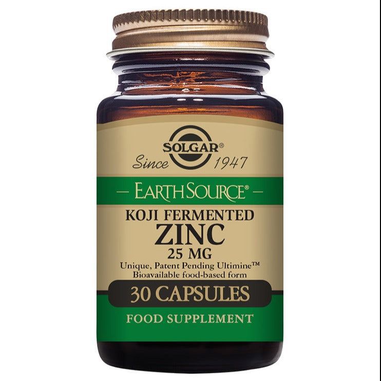 Solgar Earth Source Koji Zinc sinkki; ruskea lasipullo kultaisella kierrekorkilla ja mattapintaisella etiketillä, sisältää 30 kapselia 25 mg annostuksella; beigepohjaisessa etiketissä vihreää, mustaa ja kultaista antiikva- ja groteskitekstiä ravintolisästä sekä biosaatavasta, ruokapohjaisesta sinkistä; valkoinen tausta.