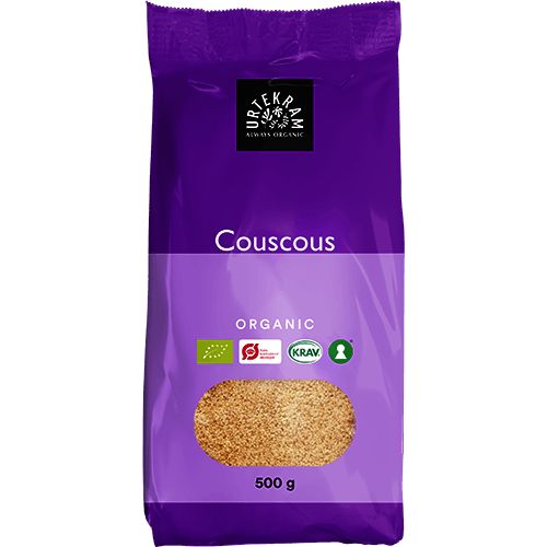 A 500g bag of Urtekram organic wholemeal couscous in a purple package, displaying certification logos for organic standards. The packaging is matte and rectangular with a resealable top. White sans-serif lettering shows the product and brand names. Several logos appear near the bottom front. The background is neutral, isolated product shot with no people or props visible.