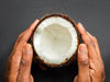 Halkaistu kookospähkinä ihmisen käsissä