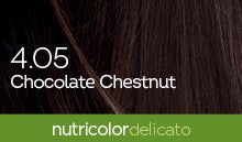 Biokap Nutricolor Delicato Kestoväri; lähikuva tummanruskeasta tukasta tekstillä 4.05 Chocolate Chestnut ja vihreä palkki alaosassa tekstillä nutricolor delicato, korostaen rikasta ja eloisaa väriä; kuva suorakulmaisessa muodossa kiiltävin tekstuurisin hiussuortuvin; teksti valkoista ja lihavoitua groteskia läpinäkyvällä peitolla; ei ihmisiä tai käsiä; taustalla vain hiustekstuuri, ei pakkausta tai muita esineitä.