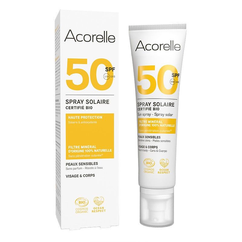 Acorelle Aurinkosuojasuihke Kasvoille ja Vartalolle SPF50: sertifioitu luomuaurinkosuihke herkälle iholle valkoisella ja keltaisella pakkauksella; muovituubi mattapinnalla vierekkäin suorakulmaisen kartonkirasian kanssa, molemmissa tuotetietoa ranskaksi ja englanniksi lihavoidulla groteskikirjasimella; kuvattu vaaleaa taustaa vasten, ei ihmisiä tai käsiä näkyvissä.