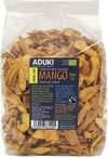 A clear plastic bag of Aduki brand dried mango slices features a blue and yellow label displaying product information in multiple languages, including ingredients. The label uses sans-serif fonts in white and black, with block lettering for the brand name. The dried mango slices are orange and irregularly shaped. The package is sealed with a horizontal seam at the top. Plain white background, no people or props shown.