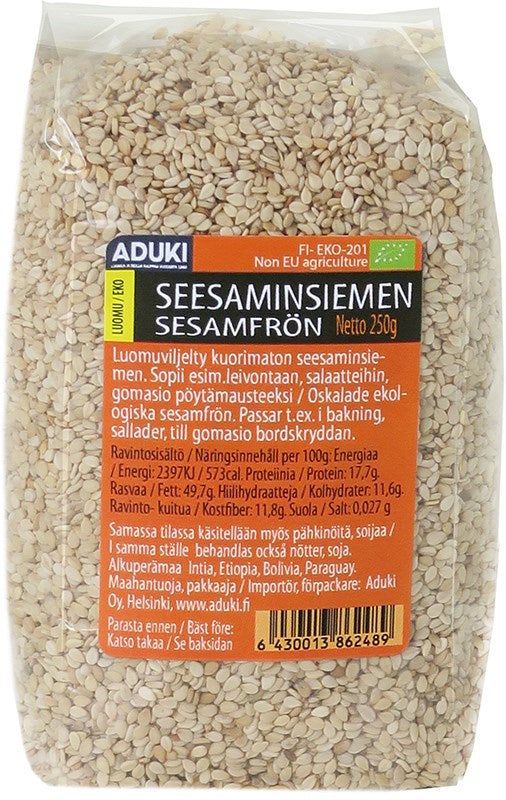 Aduki Luomu Seesaminsiemen; kirkas muovipussi tekstillä Aduki sisältää 250 g luomuseesaminsiemeniä, tuotetieto sekä suomeksi että ruotsiksi painettu etuosaan; pakkaus suorakaiteen muotoinen kiiltäväpinnalla, näyttää läpinäkyvin osin beigejä siemeniä sisällä; sertifikaatit kuvakkeina alaosassa viivakoodin vieressä; ei ihmisiä tai taustaelementtejä näkyvissä tässä suoraviivaisessa tuotekuvassa.