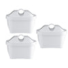 Three white plastic water filter cartridges with round openings on top are arranged in a triangular pattern against a plain white background. The cartridges are cylindrical, made of smooth matte plastic, unwrapped with no visible labels or text. No hands, people, or additional objects are present in the image.