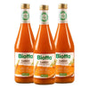 Three glass bottles of Biotta Carrot Juice, labeled as organic and rich in vitamin A, stand side by side. Labels display orange carrot graphics, green sections with white text, and the Biotta logo in bold sans-serif lettering. Each bottle has a glossy transparent surface, tapered shape, and is topped with a white screw cap featuring green and silver seals. The background is plain white. No people are visible.