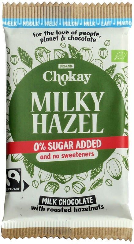 Chokay Milky Hazel -maitosuklaapatukka paahdetuin hasselpähkinöin, merkitty 0% lisättyä sokeria ja ilman makeutusaineita, vihreässä ja valkoisessa mattapakkauksessa painetuin hasselpähkinäkuvituksin. Reilun kaupan ja luomusertifikaattilogot ovat näkyvissä. Pakkaus on suorakulmainen. Pääteviivatonta fonttia eri painoin näkyy etupuolella. Ihmisiä tai käsiä ei näy; tuote on kuvattu pelkistettyä taustaa vasten suoraviivaisessa tuotekuvassa.