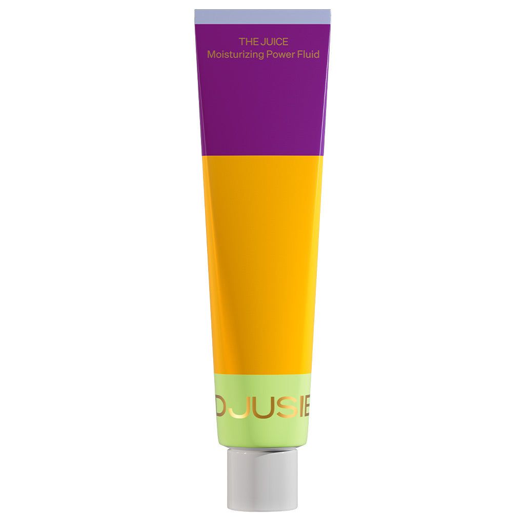 A colorful tube labeled THE JUICE Moisturizing Power Fluid features blocks of purple, orange, yellow, and green arranged vertically. The tube has a white cap at the bottom and a glossy finish. The product is cylindrical and plastic. Typography is bold and sans-serif on the front. There are no people or hands visible; background is plain and light-colored.