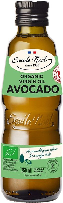 A bottle of Emile Noël Organic Virgin Avocado Oil stands upright, made of dark glass with a matte finish. The bottle has a green label with white and yellow text, displaying the brand name, product details, a red organic certification seal, and an illustration of a ripe avocado slice. No people or actions present. Plain white background. A bottle of Emile Noël Organic Virgin Avocado Oil, featuring a green label with product details, a red organic certification seal, and an illustration of a ripe avocado