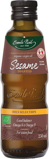 A brown glass bottle with a glossy surface, cylindrical shape and narrow neck, features an Emile Noel label in green and gold tones. The label displays “organic virgin oil,” volume as 250ml, and mentions Omega 6 & 9 with a note about Asian cuisine. No people or hands are visible. Neutral plain background, product photographed front-facing at eye level. A brown bottle of Emile Noel toasted sesame oil, labeled organic virgin oil, 250ml, with notes about Omega 6 & 9, ideal for Asian cuisine.