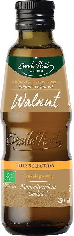 A bottle of Emile Noel organic virgin walnut oil, labeled as first cold pressing and naturally rich in Omega 3, with a green and gold label. The 250 ml bottle highlights its organic quality. Glass bottle with a dark finish, cylindrical shape, glossy surface, plastic screw cap. Printed main text in white and gold serif font on matte-finish label. Neutral background; product centered; no people or other objects visible.