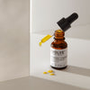 Kullanhohtoista Bio-Retinol + C Booster -seerumia pipetissä pullon yläpuolella