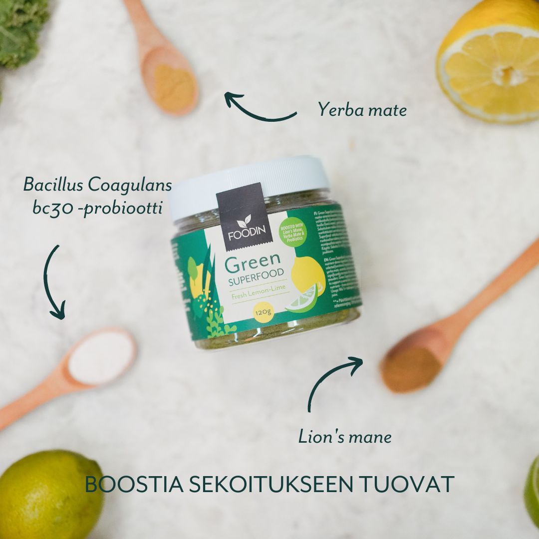 Foodin Green Superfood Fresh Lemon-Lime; purkki sitruunoiden, limen, puulusikoiden ja valkoisen jauheen ympäröimänä; musta mattapintainen kierrekorkki, etiketissä selkeä groteskiteksti ja vihreitä korostuksia; nuolet osoittavat ainesosia kuten yerba mate, lion's mane ja Bacillus Coagulans bc30 -probiootti; teksti "BOOSTIA SEKOITUKSEEN TUOVAT"; valkoinen tausta, kuvattu ylhäältä, ei ihmisiä tai käsiä.