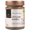 A glass jar of Foodin brand organic Ceylon cinnamon with a copper lid, white label, and black text. The label has a botanical-style illustration and the text “organic” and “50g” are clearly displayed. The surface is glossy, the jar has straight sides, and the background is plain. No people or hands visible. Close-up product shot.