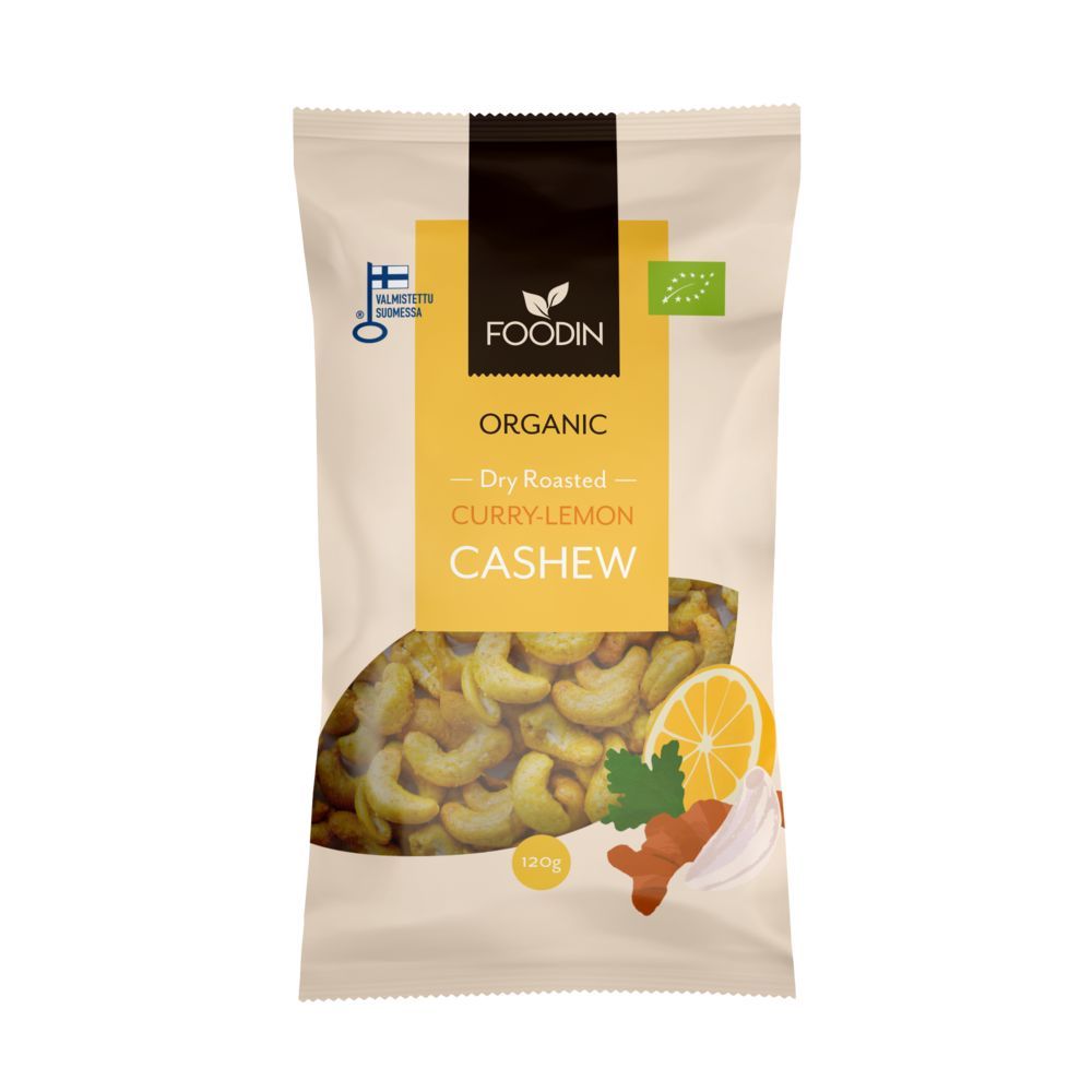 Foodin Luomu Curry-Lemon Cashew; beige pussi Foodin-merkkisille luomu-kuivapaahdetuille curry-sitruunacashewpähkinöille, etusivulla kuvia cashewpähkinöistä, sitruunasta ja mausteista sekä luomusertifiointimerkki oikeassa yläkulmassa; mattapintainen suorakulmainen pakkaus; fontti lihavoitu ja moderni; pussi pystyssä neutraalia taustaa vasten studiokuvassa, ei ihmisiä tai käsiä.