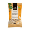 Foodin Luomu Paahdettu Cashew; 140 g pussi Foodinin luomuluomu-paahdetuille cashewpähkinöille oranssin, keltaisen ja ruskean mattapintaisin pakkausvärein; suorakulmainen, pystyssä oleva pussipakkaus; luomu- ja suomalaiset sertifiointilogot lähellä yläreunaa; kirkas ikkuna etusivulla näyttää kokonaiset cashewpähkinät sisällä; groteskityyppografia luettavassa tuotenimitekstissä; pakkaus avaamattomana pystyssä valkoisella taustalla studiokuvassa.