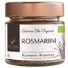 A glass jar of Foodin organic rosemary with a rose-gold metal lid, cylindrical shape, and clear body showing dried rosemary leaves. The surface of the jar is glossy. The label is matte, dark with white sans-serif text in Finnish, German, and English stating product name and weight (18g), plus simple green botanical illustrations. Studio-style white background. No people or hands present.