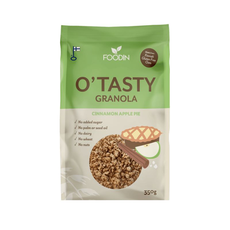 A 350g bag of Foodin OTasty Granola, Cinnamon Apple Pie flavor. Matte-finish flexible packaging shows images of granola, a baked pie, cinnamon sticks, and an apple slice. Main label has bold sans-serif text and smaller icons listing no sugar, no nuts, no dairy, and no palm or seed oil. Product is displayed against a plain background with no people visible. Enjoy the comforting taste of cinnamon in every bite.