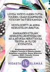 A Finnish text card featuring watercolor flowers and feathers. Rectangular, made of matte white card stock with multicolored floral and feather designs framing centered black sans-serif Finnish text. Smaller publication and creator details are printed at the bottom. Product is unboxed, photographed against a plain light background with no hands or people visible.