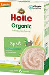 A box of Holle Organic Wholegrain Spelt Cereal for babies from 6 months, featuring a green duck, wheat, and a bowl of cereal on the front. This climate positive cereal is dairy-free and contains no added sugar. The box is rectangular with a matte finish and predominantly cream and yellow colors. Simple serif font displays product information. Packaging placed against a plain white background in a straightforward product shot. No people or hands are visible.