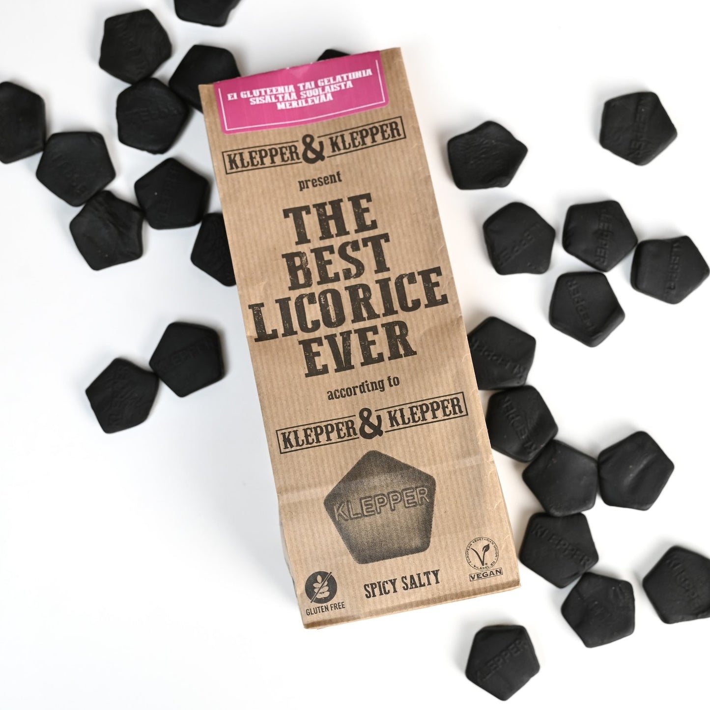 Klepper & Klepper Spicy Salty -lakritsipussi ylhäältä, ympärillä mustia viisikulmaisia salmiakkipaloja