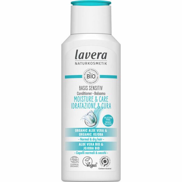 A white plastic bottle of Lavera Basis Sensitiv conditioner for normal and dry hair, with a matte finish and rounded edges. The front label displays text about organic aloe vera, jojoba, vegan certification, organic status, and carbon-neutral claims using sans-serif fonts in blue and black. No people or hands are visible. Neutral background with simple lighting. A white bottle of Lavera Basis Sensitiv conditioner for normal and dry hair, featuring organic aloe vera and jojoba. The label highlights vegan,