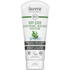 A white tube of Lavera Body Scrub featuring green text and images of rosemary and coffee beans, labeled as organic, vegan, and climate neutral, with multilingual product details. Tube has a matte surface and rounded edges; green sans-serif font is used for most text. The tube stands upright against a plain light background. No people or hands are visible in the image.