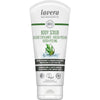 Lavera Body Scrub; valkoinen tuubi Lavera-vartalokuorinnalle vihreällä tekstillä sekä rosmariini- ja kahvipapukuvin, merkitty luomuksi, vegaaniksi ja ilmastoneutraaliksi, monikielinen tuotetieto; tuubi mattapintainen ja pyöristetyin reunoin, vihreä groteskifontti useimmassa tekstissä; tuubi pystyssä vaaleaa taustaa vasten, ei ihmisiä tai käsiä.