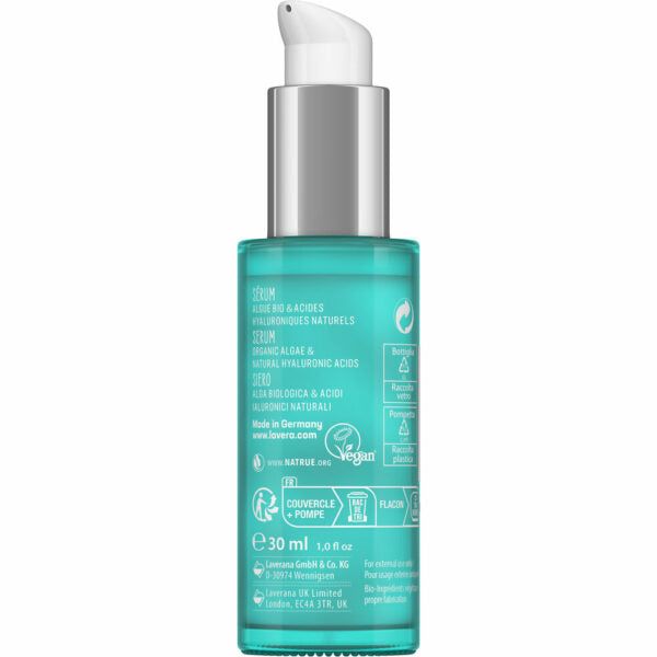 A turquoise bottle of Lavera serum with a white pump dispenser. Cylindrical shape with a matte finish. The label wraps around the front and displays product details, vegan and recyclable symbols, and text in multiple languages in compact sans-serif fonts. Volume is listed as 30 ml (1.0 fl oz). Image shows no hands or people, photographed against a neutral background.