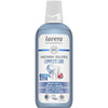 A bottle of Lavera Complete Care Mouthwash with organic mint and echinacea. Cylindrical clear plastic bottle shows blue liquid inside, white screw cap on top. White label features blue accents, sans-serif text, and small round icons for vegan and cruelty-free. Main label text is centered. The background is plain white, no people or props visible. Shot is straight-on front view of the product.