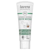 Tube of Lavera Sensitive Whitening toothpaste with coconut oil, mineral cleaning particles, and vegan certification, displayed on a white background. The tube is white with a matte finish and has a flip-top cap. The label features images of a tooth and a coconut alongside product text in sans-serif font. No people or hands are visible in the image.