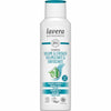 A white plastic bottle of Lavera shampoo with a glossy finish, upright oval shape, and flip-top cap. The front label shows “Volume & Strength” in large sans-serif font, mentions organic bamboo and algae. Both English and Italian text are present. Vegan and organic certifications are printed at the bottom. Plain background, no people or props visible. A white bottle of Lavera shampoo labeled Volume & Strength with organic bamboo and algae. The text appears in English and Italian, highlighting its vegan and