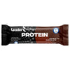 A Leader Performance Protein bar, double chocolate flavor, in a brown and black glossy wrapper with white and gold bold sans-serif text. The packaging displays “20g protein,” “lactose free,” “no added sugar,” and the Olympic Team Finland logo. Product is rectangular and sealed. Neutral background; no people or other objects visible.