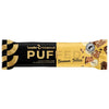 A yellow and black wrapper for Leader Promour Puffed Banana Toffee bar, featuring images of the bar and its ingredients. Matte packaging with both serif and sans-serif text styles. Front of package displays product name, flavor, and icons or text for high protein, fiber, no added sugar, no palm oil. Bar shape is rectangular. Neutral studio background with no hands or people visible.