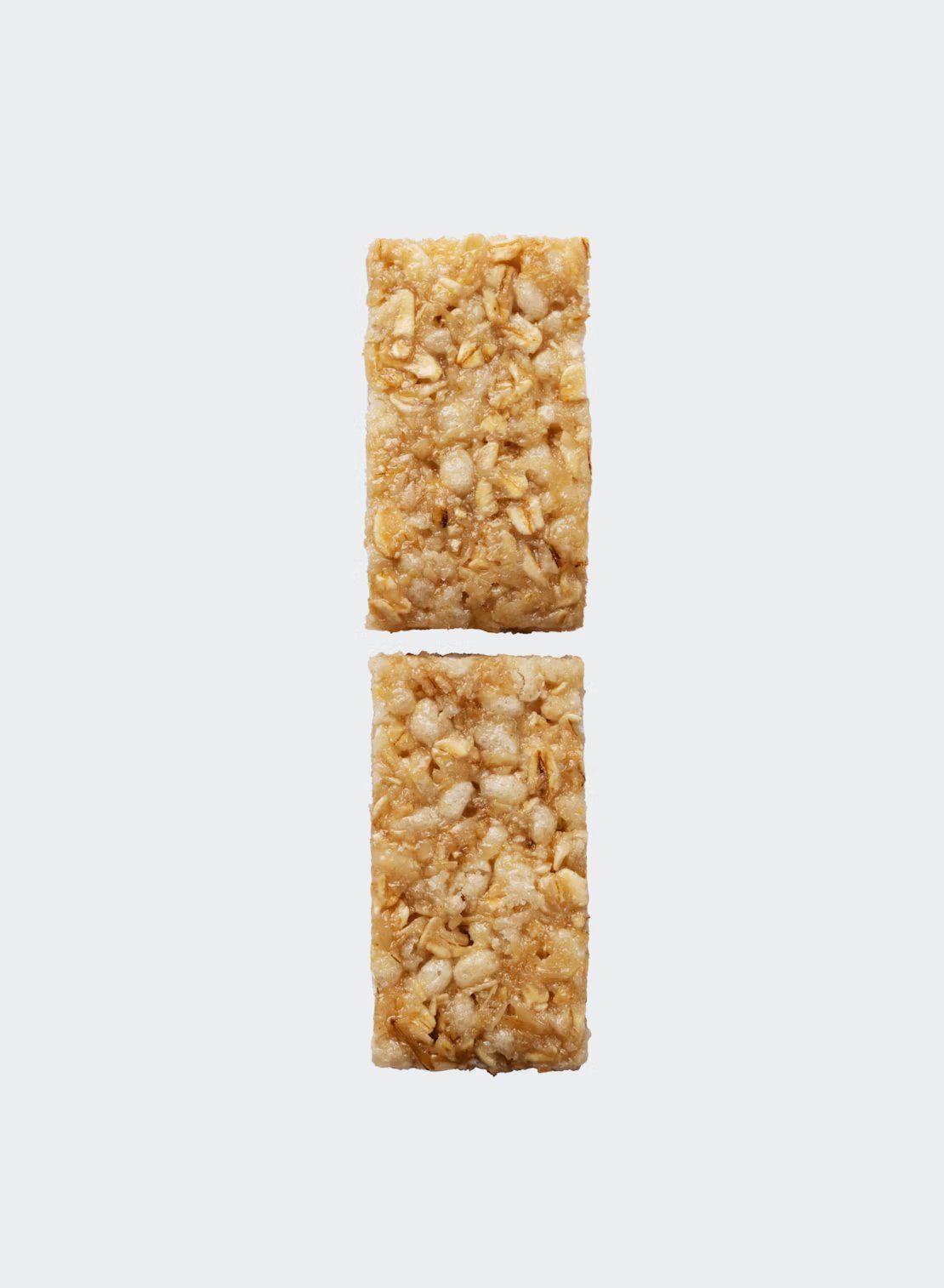 Two rectangular oat and nut granola bars are arranged vertically on a plain white background, with a small gap between them, highlighting their wholesome blend of oats and nuts. The bars have a rough, matte texture with visible pieces of oats and nuts on the surface. No packaging, labels, typography, people, or props are present in the image.