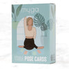 A rectangular box with the label “myga YOGA POSE CARDS” shows an illustrated figure in a yoga pose, surrounded by tropical leaves and four small, colorful rectangular cards arranged below. Box design uses clear, bold sans-serif typography and has a matte finish. Text mentions “planet friendly product.” The item is photographed against a plain background in even lighting. A box labeled myga YOGA POSE CARDS features an illustration of a person in a yoga pose surrounded by tropical leaves and four colorful