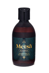 A dark brown bottle with a black cap labeled Ole Hyvä Metsä Kaarna Shampoo & Suihkugeli features a teal and gold label. The bottle is cylindrical with a matte finish. The label uses bold sans-serif typography in white and gold on a teal background with abstract pattern accents. The product is photographed upright against an even, neutral background with no people or hands visible.
