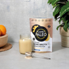 Planet Paleo Vanilla & Baba -pussi pöydällä kasvin ja valmiin juoman vieressä