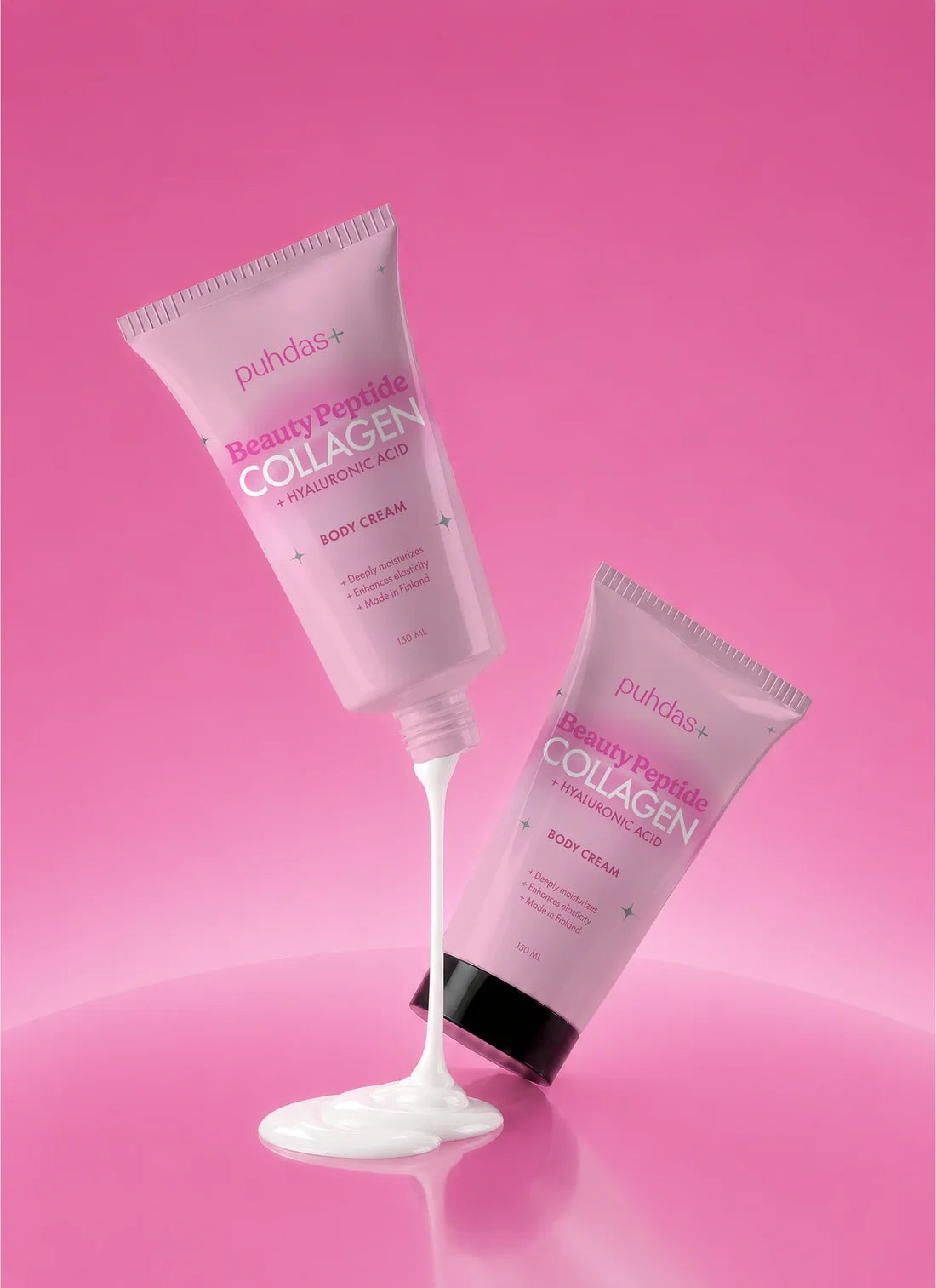 Kaksi Puhdas+ Beauty Peptide Collagen -vartalovoidetuubia pinkillä taustalla, toisesta valuu voidetta