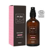 A brown spray bottle labeled Pure Beauty Rose Mist with Prebiotics stands next to its pink box, featuring the ECOCERT Cosmos Organic logo. The bottle has a cylindrical shape with a black sprayer; both bottle and box have matte finishes. Typeface is modern sans-serif, with “Prebiotics” text shown prominently. No people or hands are present in the image. Shot is on a plain background.